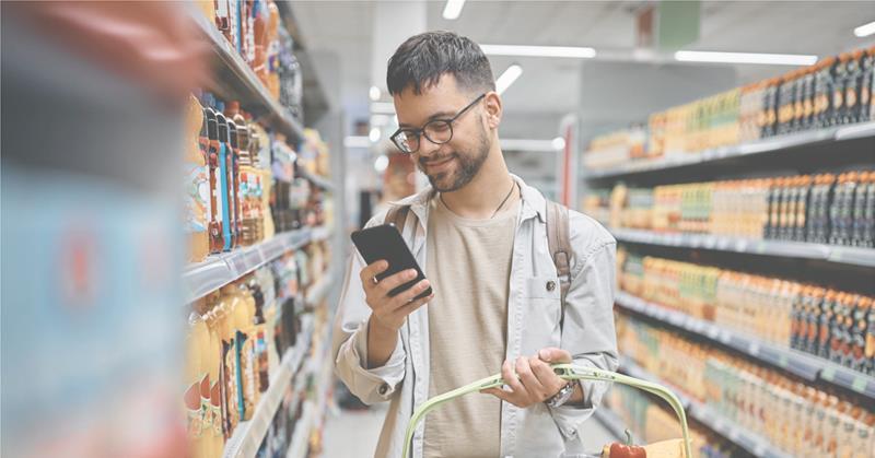 Man browsing his phone while shopping grocery